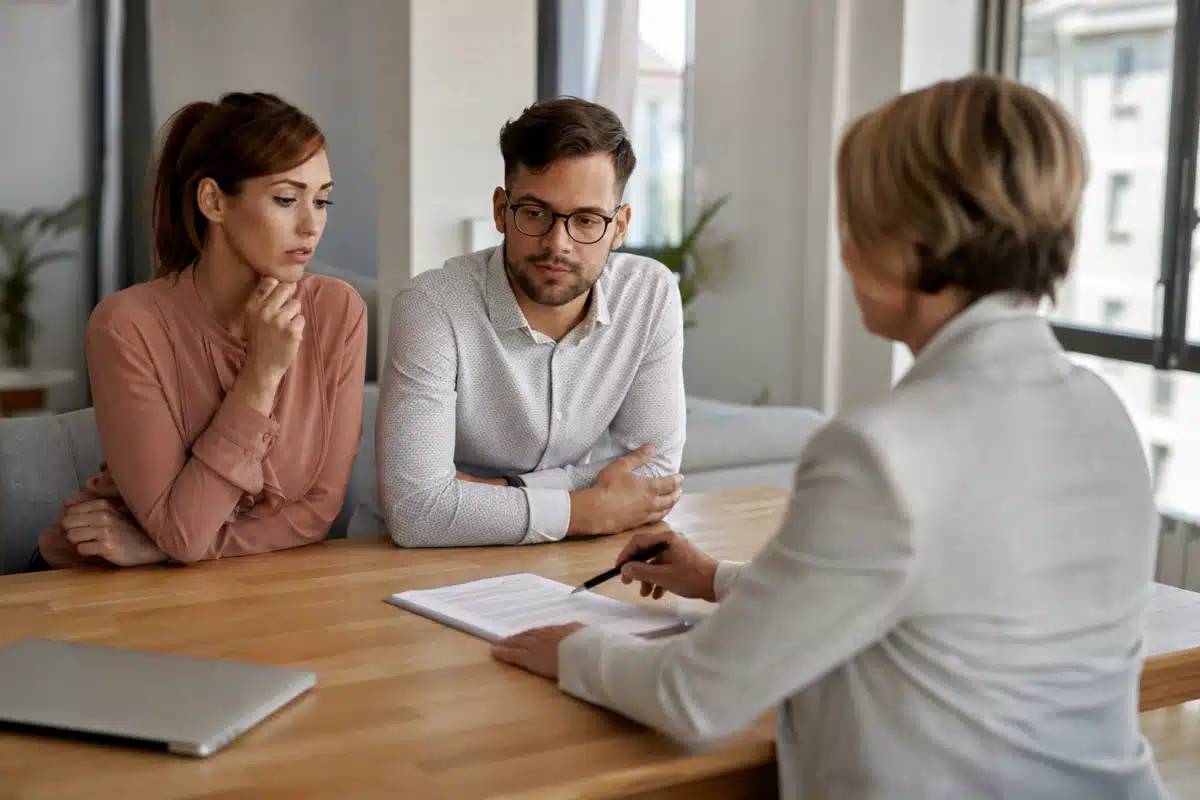 Couple sérieux discutant avec une thérapeute au bureau
